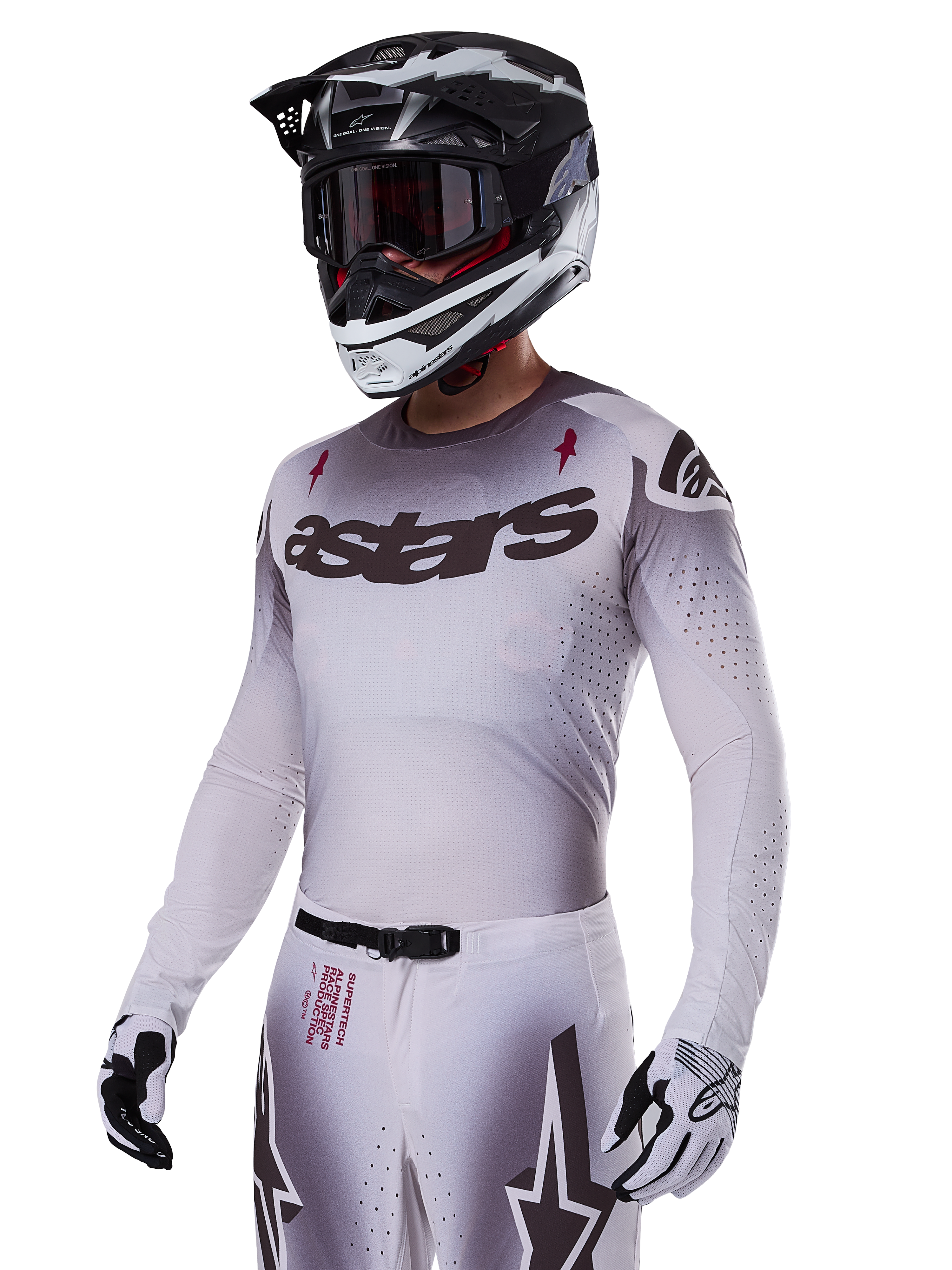 Alpinestars 2025 Supertech Maker Jersey, Motocross Racing Jersey, Silver and Black gradient, breathable stretch mesh with laser-cut perforations, worn with matching pants and helmet, featuring 'astars' branding, complete professional off-road gear