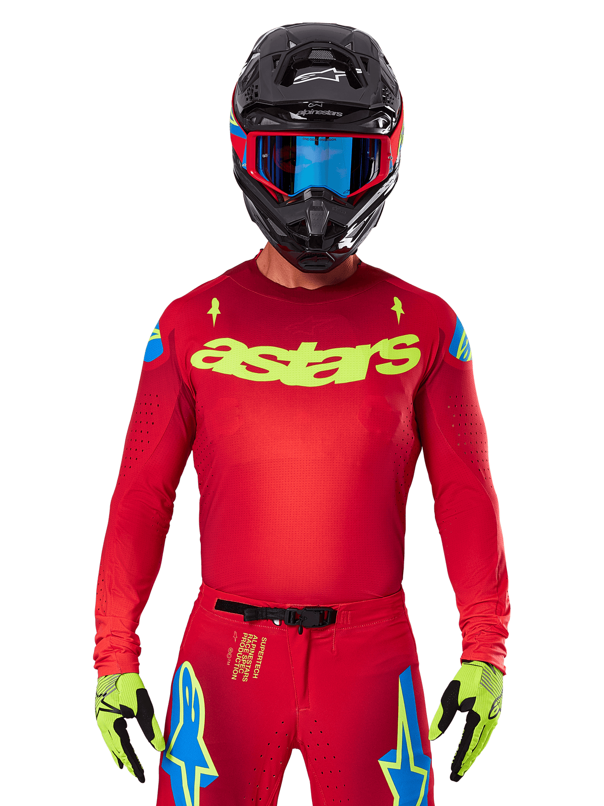Alpinestars 2025 Supertech Maker Jersey in leuchtendem Rot und Gelb Fluo, mit gelbem „astars“-Branding auf der Brust und blauen Stern-Designs an den Schultern, getragen mit passender Hose, schwarzem Helm, blauer Brille und gelben Handschuhen, professionelle Motocross-Rennbekleidung