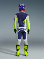 Back view of a motocross rider wearing the Alpinestars 2026 Racer Air Riway Jersey and matching pants in Light Gray Yellow Fluo Blue, paired with bright yellow fluo boots and a coordinated helmet, showing a complete off-road racing gear set.