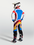 Alpinestars Supertech Dyna Gear Set, blau-weißes Motocross-Outfit für Herren, athletische Passform, Rückansicht eines Fahrers.