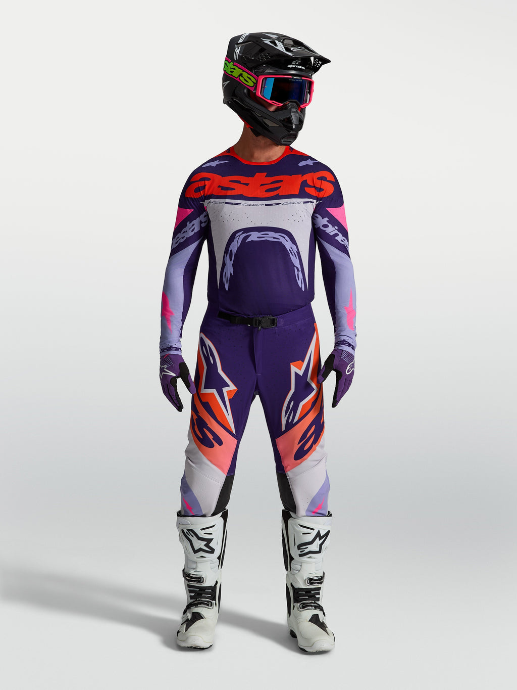 Alpinestars Supertech Dyna Trikot, Motocross-Renntrikot für Herren, Lila und Pink Fluo, athletische Passform, getragen von einem Fahrer mit Helm und Stiefeln.