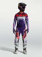 Alpinestars Supertech Dyna Trikot, Motocross-Renntrikot für Herren, Lila und Pink Fluo, athletische Passform, getragen von einem Fahrer mit Helm und Stiefeln.