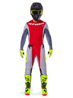 Motocross-Fahrer im Alpinestars 2025 Techstar Melt Gear Set, rotes Trikot mit grauen Ärmeln und weißem Logo, passende grau-rote Hose, fluorgelbe Brille, Handschuhe und Stiefel, komplette Motocross-Rennausrüstung für Offroad-Performance