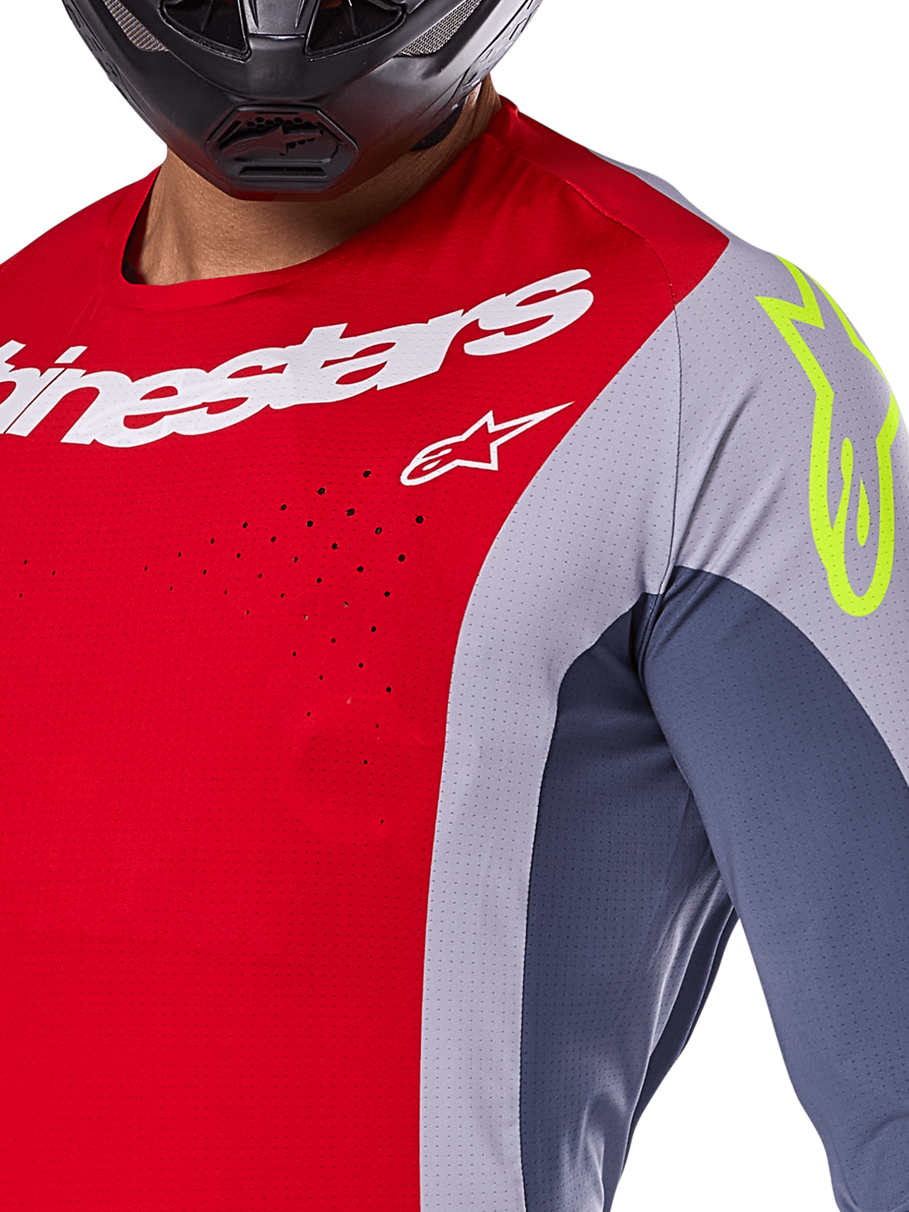 Alpinestars 2025 Techstar Melt Trikot, Motocross-Trikot, Hellrot und Grau mit dunkelblauen Einsätzen, mit weißem Alpinestars-Branding und einem neongelben Logo auf der Schulter, Nahaufnahme mit lasergeschnittenen Belüftungsperforationen und einem schwarzen Helm.