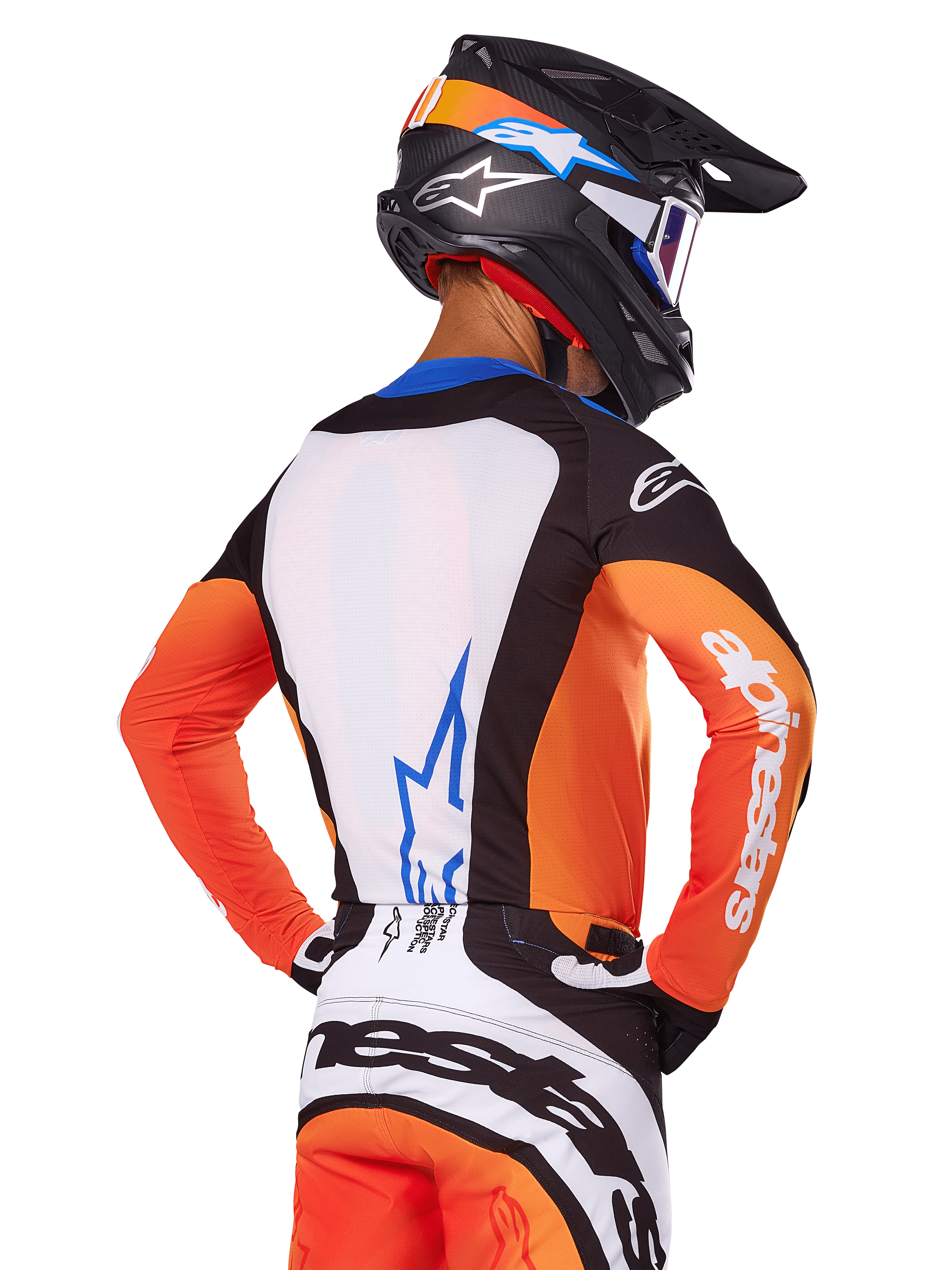 Motocross-Fahrer mit Alpinestars 2025 Techstar Melt Trikot, Orange und Blau, Rückansicht mit weißer Rückenpartie und blauem Logo, orangefarbene Ärmel mit weißem Branding, passender Motocross-Helm und Hose, professionelle Rennausrüstung.