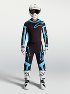 Alpinestars Supertech Vesta Trikot und Ausrüstungsset, Herren-Motocross-Outfit in Schwarz und Türkis, kombiniert mit weißen Stiefeln und Helm für professionelle Offroad-Performance.