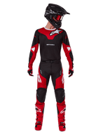 Motocross-Fahrer im Alpinestars 2025 Racer Veil Gear Set, Trikot in Schwarz und Bright Red mit weißem Alpinestars-Logo, passende Motocross-Hose, schwarzer Helm mit roter Brille, rote Stiefel, komplette Performance-Ausrüstung für das Offroad-Fahren