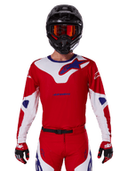Alpinestars 2025 Racer Veil Trikot, Motocross-Trikot, Rot, Weiß und Blau, Langarm, getragen mit schwarzem Helm und orangefarbener Brille, dazu passende rote Handschuhe und Hosen, schlankes Performance-Design für Offroad-Fahrten