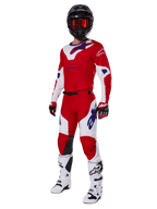 Alpinestars 2025 Racer Veil Gear Set, Motocross-Rennausrüstung, leuchtendes Rot und Weiß mit blauen Logo-Akzenten, getragen mit schwarzem Helm, roten Handschuhen und weißen Stiefeln, vollständige Schutzausrüstung für Offroad-Performance