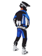 Motocross-Fahrer in kompletter Rennausrüstung von hinten gesehen, 2025 Racer Veil Trikot und passende Hose in Blau und Schwarz, mit weißem Alpinestars-Branding, schwarzem Helm, weiß-schwarzen Stiefeln, koordiniertes Outfit für den Offroad-Rennsport