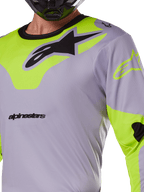 Alpinestars 2025 Racer Veil Trikot, Motocross-Trikot, Grau und Gelb Fluo, mit einem großen schwarzen Astars-Logo auf der Brust, neongelben Schulter- und Ärmeleinsätzen, technisches Mesh-Gewebe für den Offroad-Rennsport
