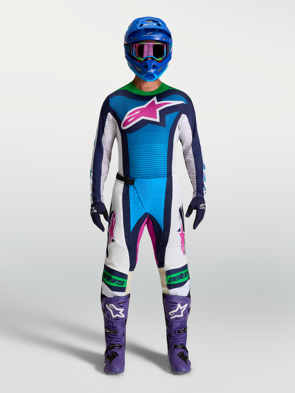 Alpinestars Techstar Maven Trikot, blau-weiße Motocross-Rennbekleidung mit pinken Akzenten und lila Stiefeln am Modell.