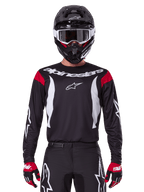 Alpinestars 2025 Fluid Haul Trikot und Bekleidungsset für Herren, schwarz-weißes Motocross-Outfit mit roten Akzenten.