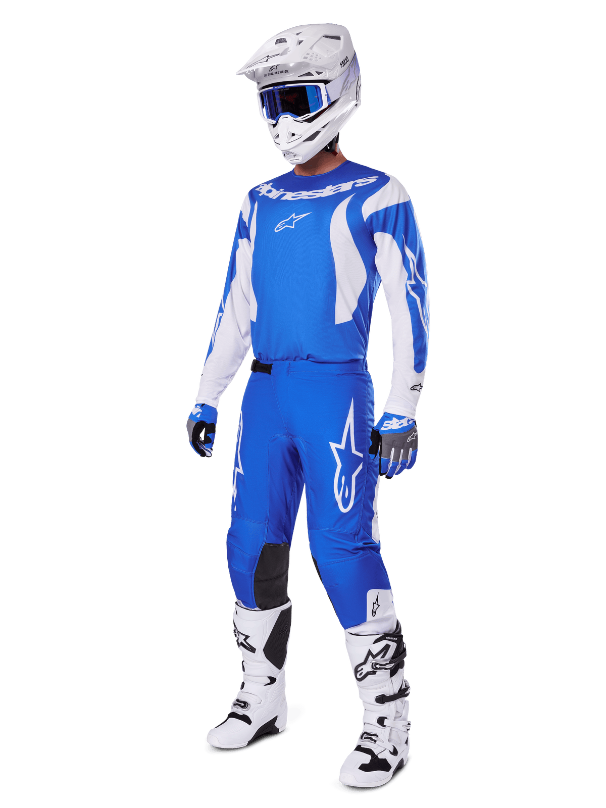 Motocross-Fahrer trägt das komplette 2025 Fluid Haul Gear Set, blau-weißes Trikot und Hose mit Alpinestars-Branding, weißer Helm mit blauer Brille, weiße Stiefel und blaue Handschuhe, koordiniertes Racing-Outfit für Offroad-Motocross.