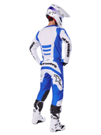 Motocross-Fahrer von hinten im Alpinestars 2025 Fluid Haul Gear Set, blau-weißes Trikot mit passender Hose, weißer Helm mit blauen Akzenten und weiß-schwarze Rennstiefel, koordiniertes Offroad-Rennoutfit