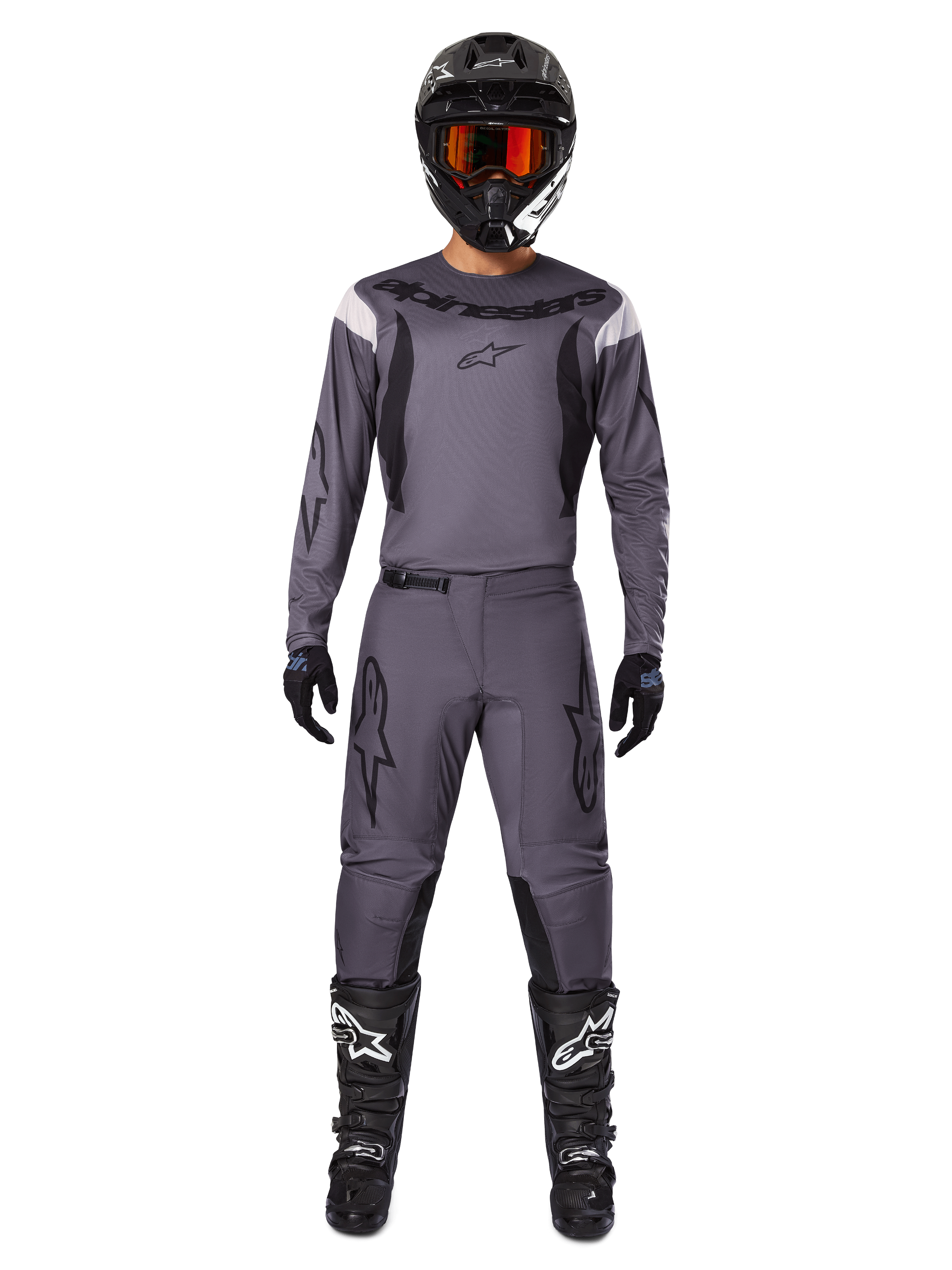 Alpinestars 2025 Fluid Haul Gear Set, Motocross-Ausrüstung, Grau, graues Trikot und Hose mit schwarzen Akzenten, schwarzer Helm mit orangefarbener Brille, schwarze Stiefel mit weißen Logos, abgestimmtes Renn-Outfit für Offroad-Performance