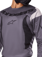 Alpinestars 2025 Fluid Haul Trikot, Motocross-Trikot, Grau mit schwarzen und weißen Akzenten, mit Alpinestars-Logo und Schriftzug auf der Brust, sportliche Passform für den Offroad-Rennsport