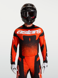 Alpinestars Techstar Swan Trikot, Motocross-Trikot für Herren, Rot und Schwarz, am Model getragen mit Helm, athletische Rennpassform.