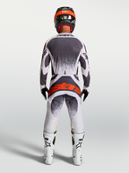Alpinestars Techstar Swan Trikot und Ausrüstungsset in Grau und Weiß, Motocross-Set mit rotem Logo, Rückansicht am Model.