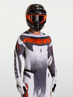 Alpinestars Techstar Swan Trikot, Motocross-Oberteil in Grau und Rot Fluo, mit Race-Fit und lasergeschnittener Belüftung.