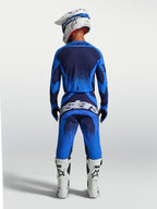 Alpinestars Techstar Swan Trikot und 2027 Gear Set, blau-dunkelblaues Motocross-Outfit, Rückansicht mit weißen Stiefeln.