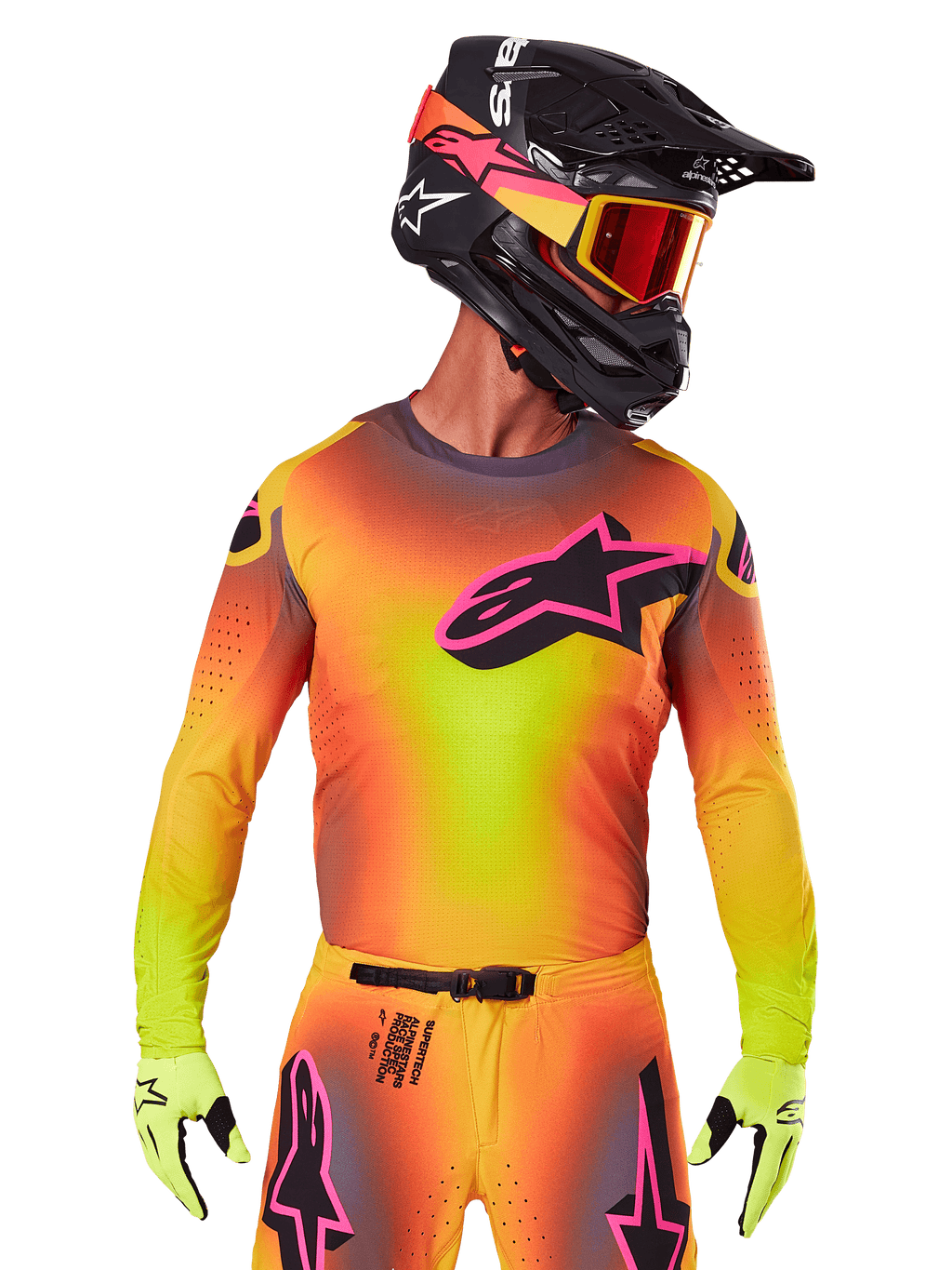 Motocross-Fahrer im 2025 Supertech Lipan Trikot, leuchtender Farbverlauf in Gelb, Orange und Pink, großes schwarzes Alpinestars Stern-Logo mit pinker Kontur auf der Brust, lasergeschnittene Perforationen zur Belüftung, athletische Rennpassform, kombiniert mit passender Hose, gelben Handschuhen und einem schwarzen Helm mit Brille.