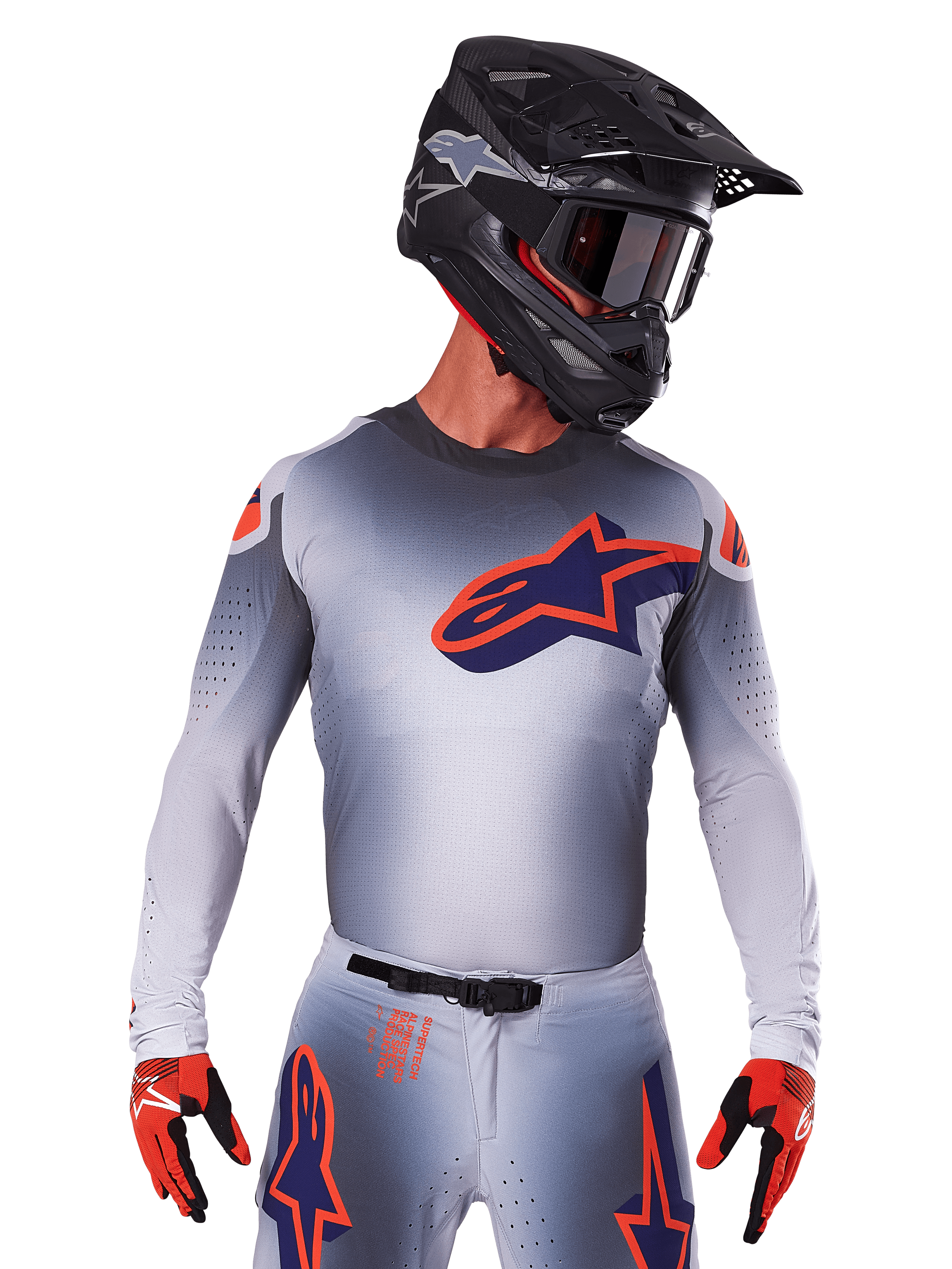 2025 Supertech Lipan Trikot, Motocross-Renntrikot, Grau mit Akzenten in Orange und Marineblau, langärmeliges Performance-Oberteil mit perforierten Belüftungsdetails, getragen mit schwarzem Helm und roten Handschuhen, schnittiges Racing-Design