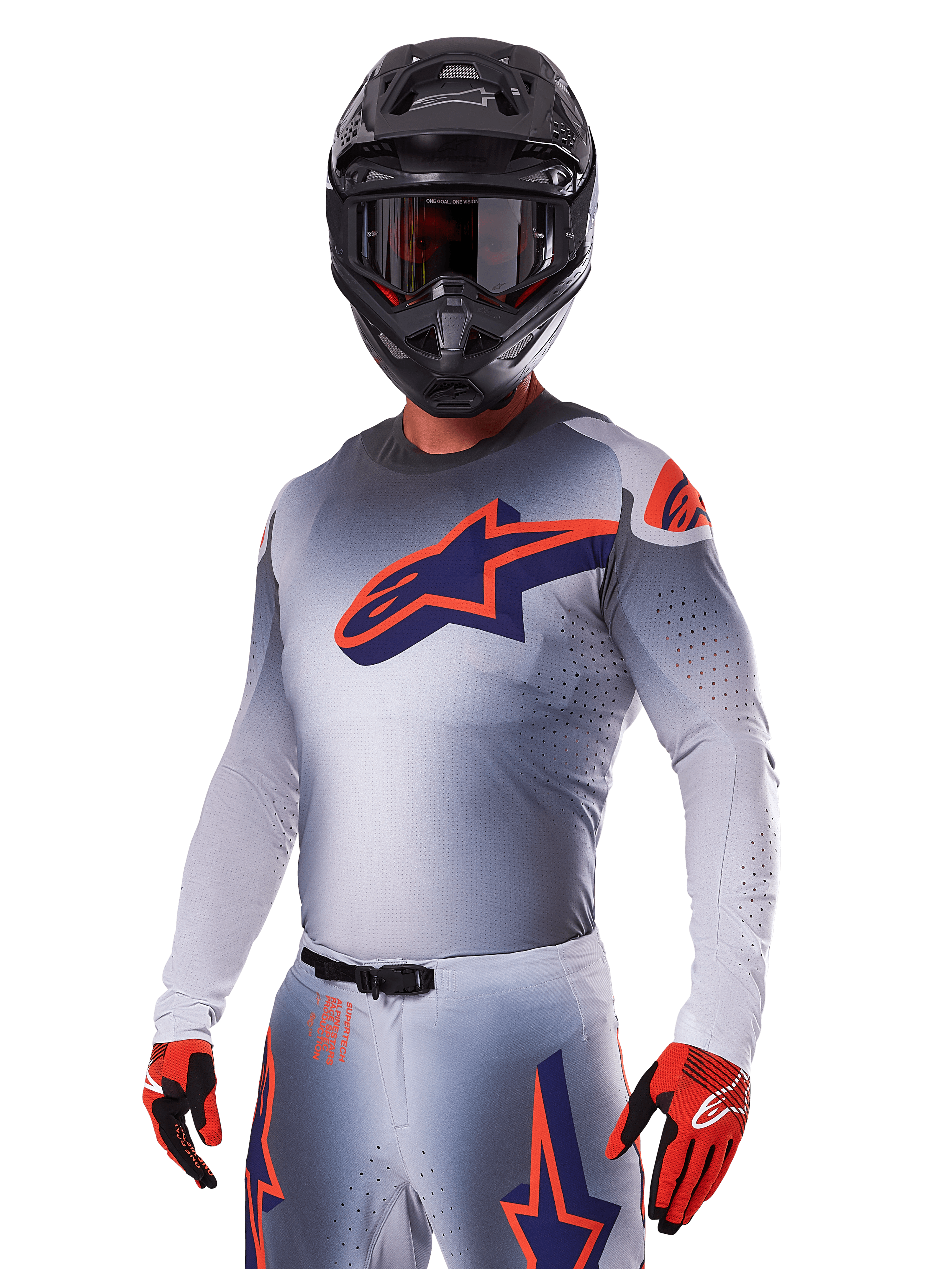 Motocross-Fahrer im Alpinestars 2025 Supertech Lipan Ausrüstungsset, graues Trikot und Hose mit navyblauen und orangefarbenen Akzenten, mattschwarzer Helm mit Brille, rote und schwarze Handschuhe, sportliche Performance-Ausrüstung für Offroad-Rennsport