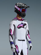 Motocross-Fahrer trägt das 2026 Supertech AFD Vista Trikot in Weiß Violett Schwarz, passende weiß-violette Hose, schwarzer Helm mit violetter Brille und weiße Handschuhe, komplette professionelle Offroad-Rennausrüstung.