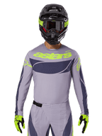 2025 Techstar Dreem Jersey und Ausrüstungsset, Motocross-Rennausrüstung, hellgrau und dunkelgrau mit neongelben Akzenten, mit „astars“-Branding, getragen mit schwarzem Helm, Brille und passenden Handschuhen, technisches perforiertes Material für Offroad-Performance