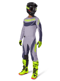 Alpinestars 2025 Techstar Dreem Gear Set, Motocross rider in full racing outfit, gray jersey and pants with dark gray patterns and neon yellow-green accents, matching black helmet, neon yellow-green gloves and boots, performance off-road gear