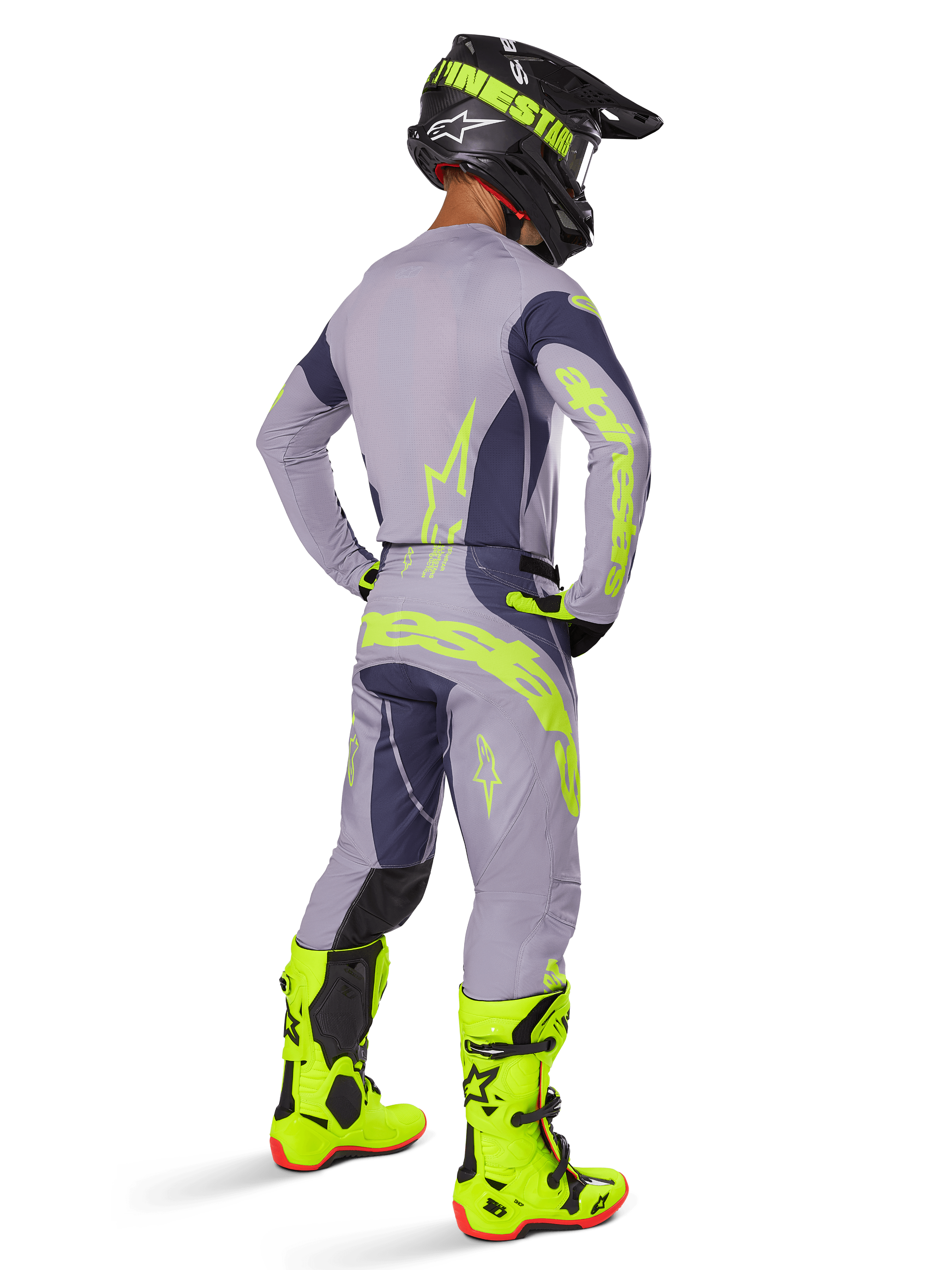 Alpinestars 2025 Techstar Dreem Trikot, Motocross-Trikot, Grau und Dunkelgrau, getragen mit passender Hose und leuchtend neongelben Stiefeln, Rückansicht mit neongelbem Branding und athletischer Passform für Offroad-Rennsport