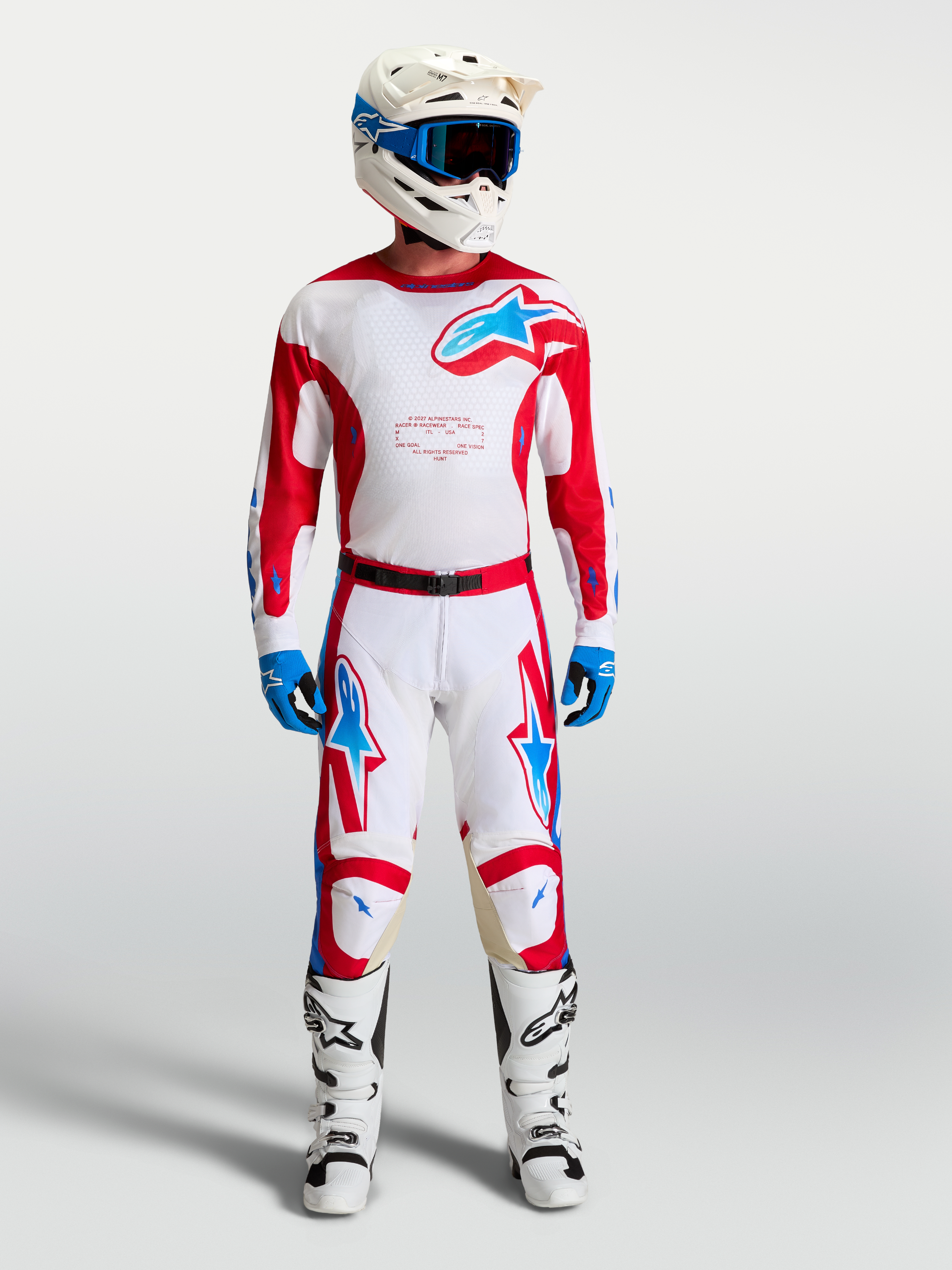 Alpinestars Racer Hose Hunt, Motocross-Hose in Weiß und Rot mit blauen Akzenten, am Model mit MX-Ausrüstung gezeigt.