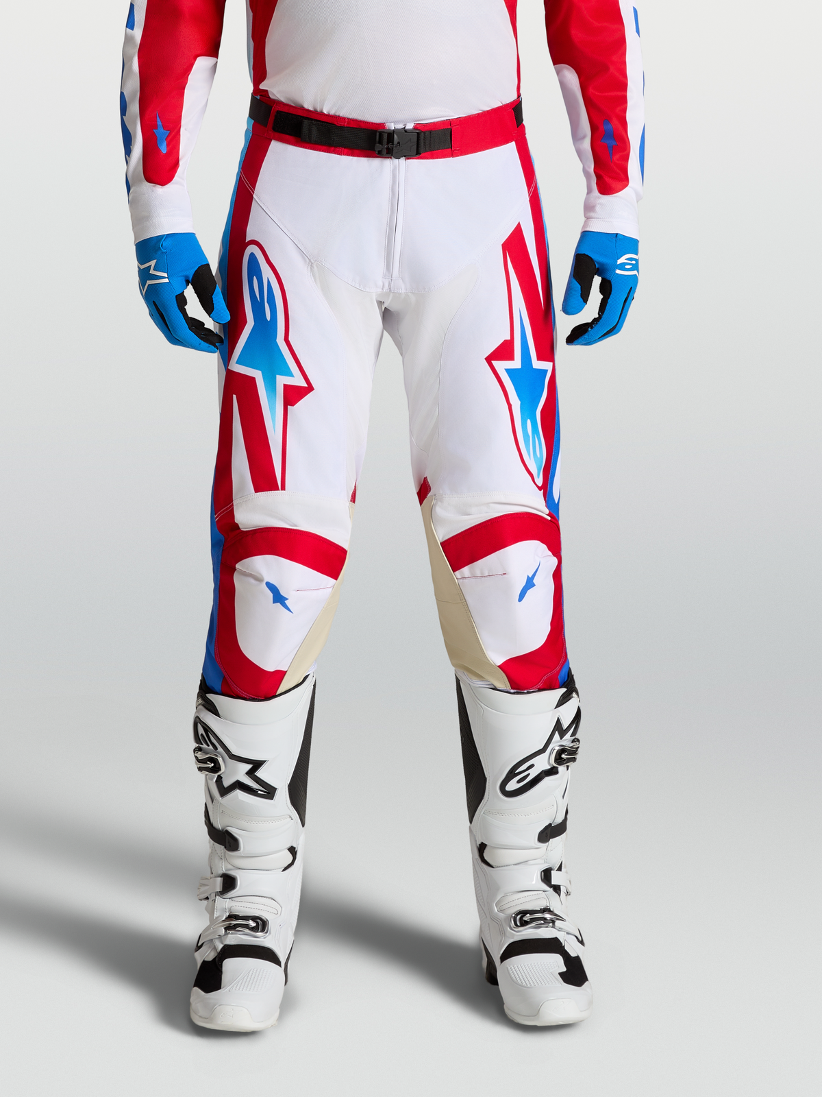 Alpinestars Racer Hunt Pants, performance motocross racing pants in white, fire red, and blue with ergonomic pre-curved legs and leather knee panels.