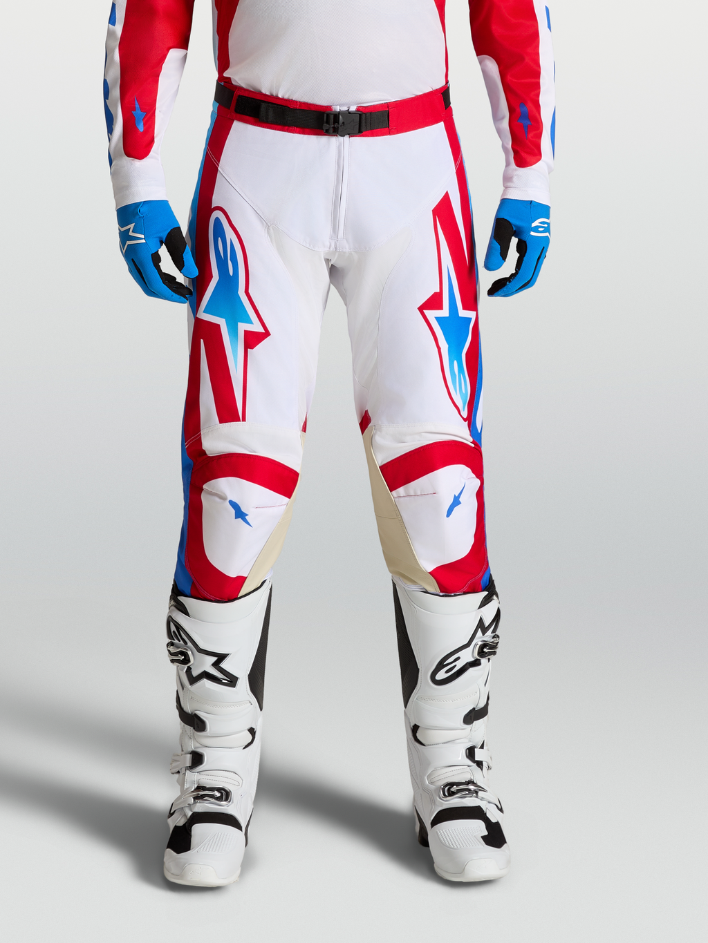 Alpinestars Racer Hose Hunt, Motocross-Hose in Weiß, Rot und Blau, on-model getragen mit Stiefeln, ergonomische Passform und Ziegenleder-Knieeinsätze.
