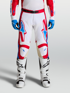 Alpinestars Racer Hose Hunt, Motocross-Hose in Weiß, Rot und Blau, on-model getragen mit Stiefeln, ergonomische Passform und Ziegenleder-Knieeinsätze.