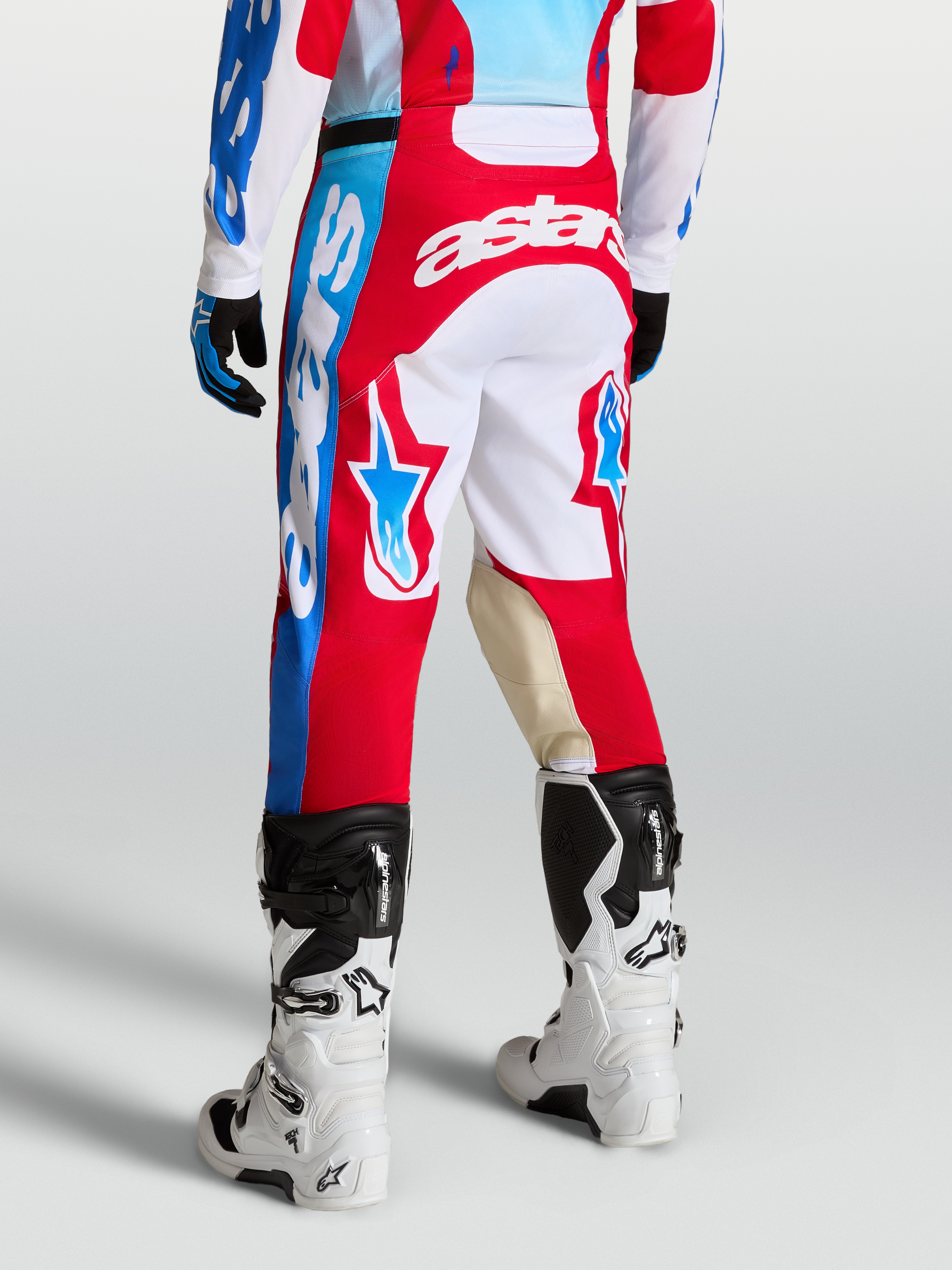Alpinestars Racer Hose Hunt, Rot und Weiß, Motocross-Hose an Model mit Sternen-Grafiken, Ziegenleder-Knieeinsätzen und ergonomischem Sport-Schnitt.