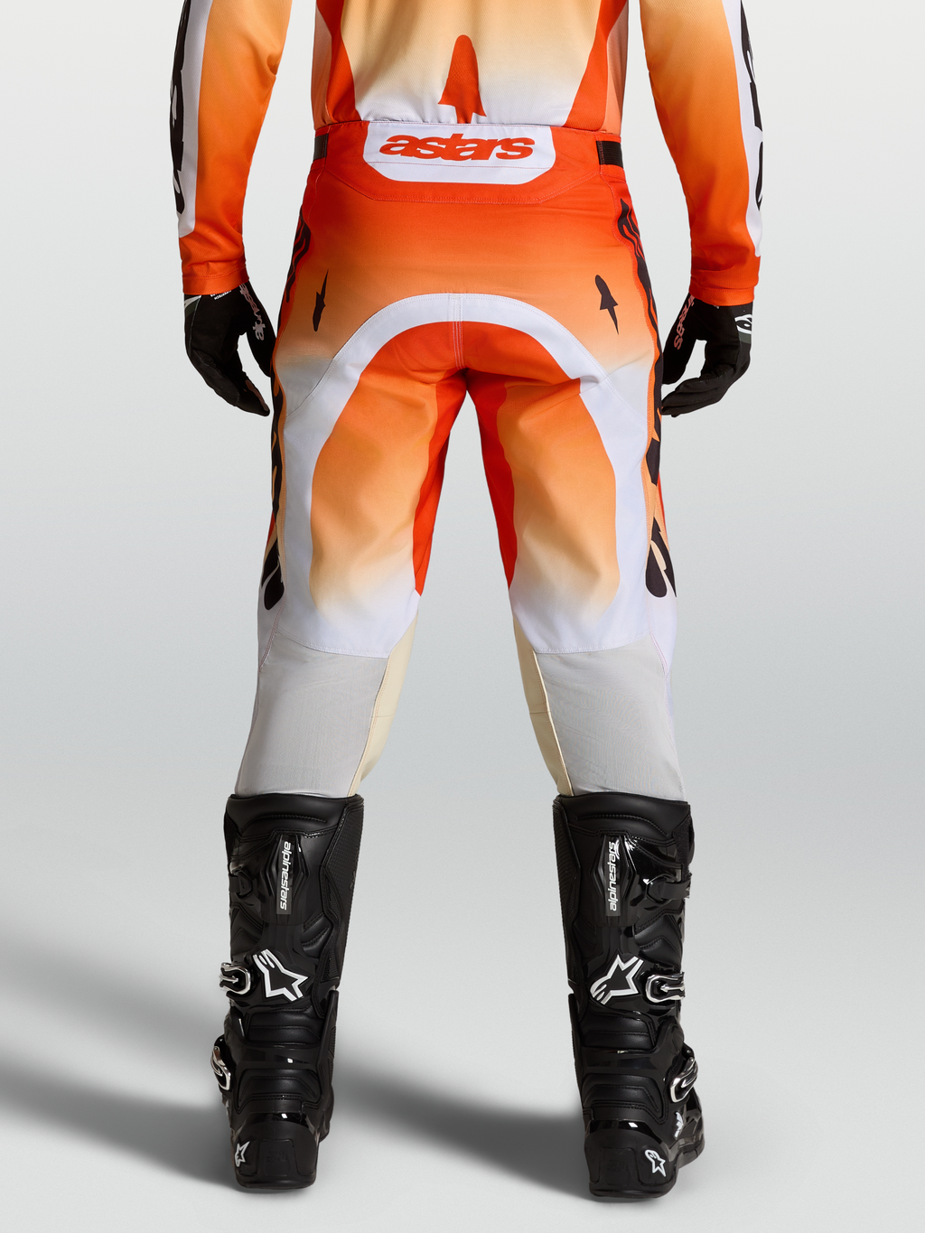 Alpinestars Racer Amber Hose, Motocross-Hose in Rot und Weiß, Rückansicht am Model mit schwarzen Stiefeln