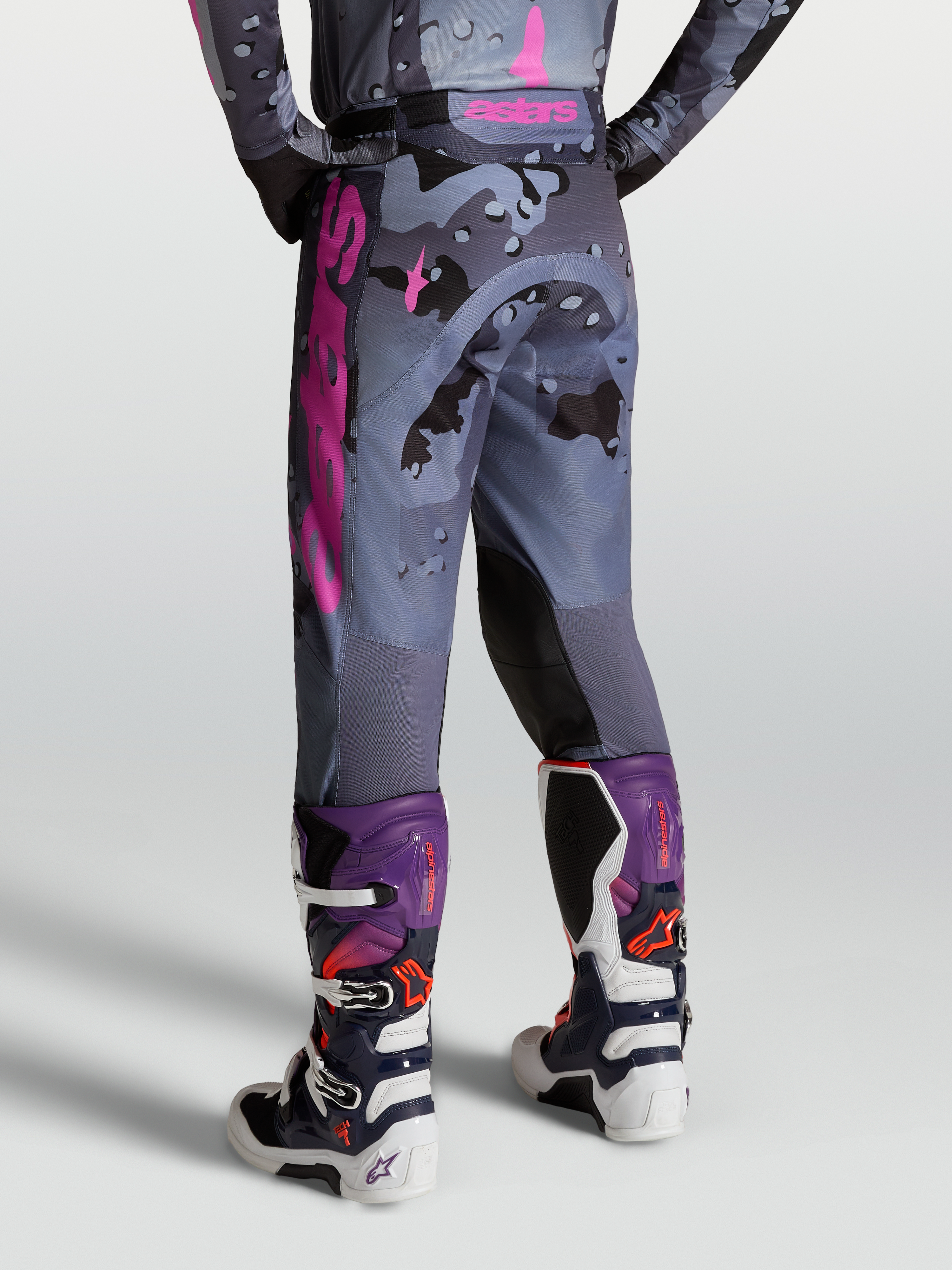 Alpinestars Racer Lone Hose, Motocross-Hose in Grau-Camo und Lila, Rückansicht am Model mit Tech 7 Stiefeln.