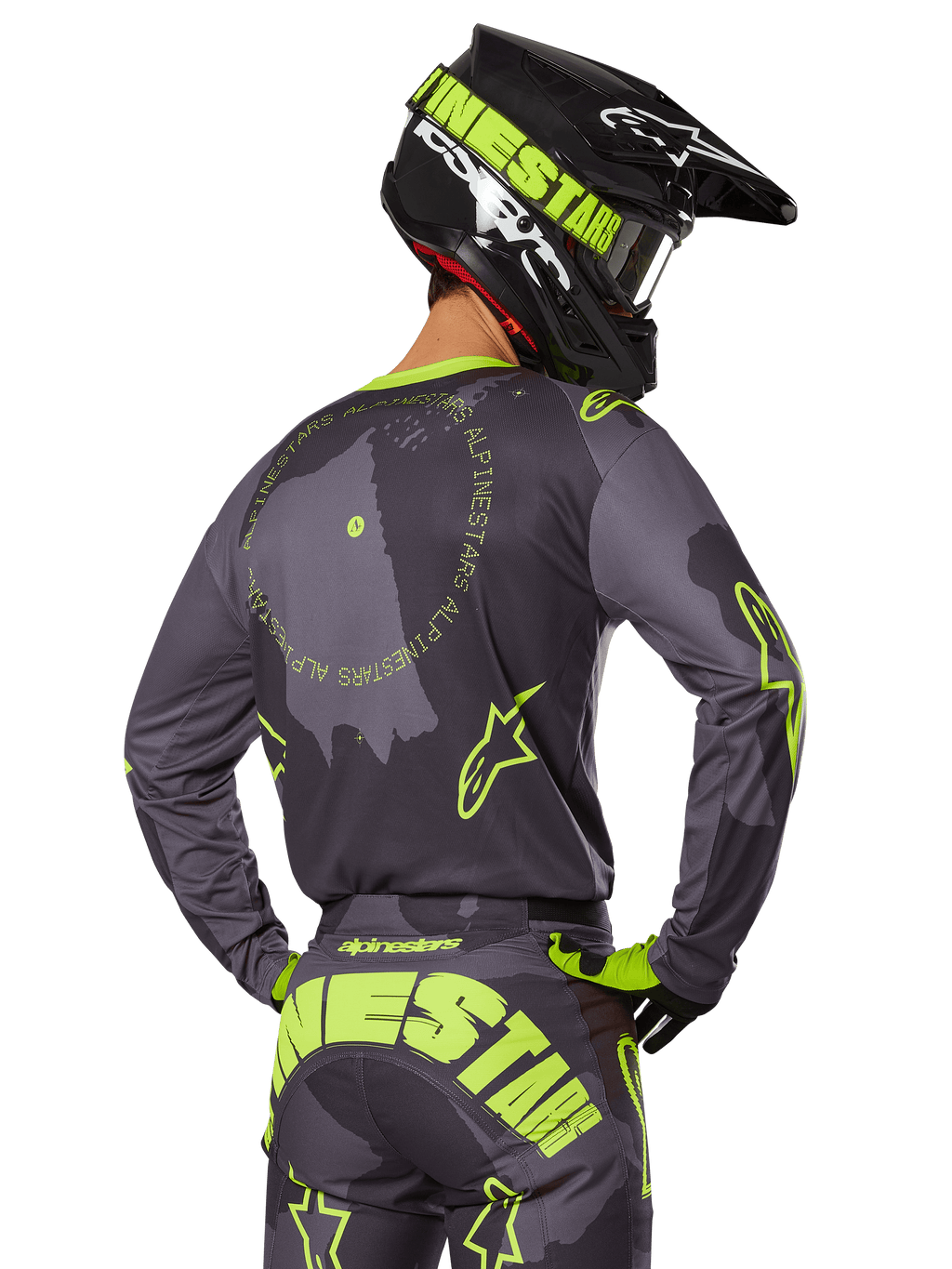 Motocross-Fahrer in der Rückansicht im 2025 Racer Hollow Gear Set, graues Trikot mit neongelbem kreisförmigem Text und Stern-Logos, passende grau-gelbe Hose mit markantem Branding auf dem Gesäß, schwarz-limonengrüner Helm, abgestimmtes Outfit für den Offroad-Rennsport
