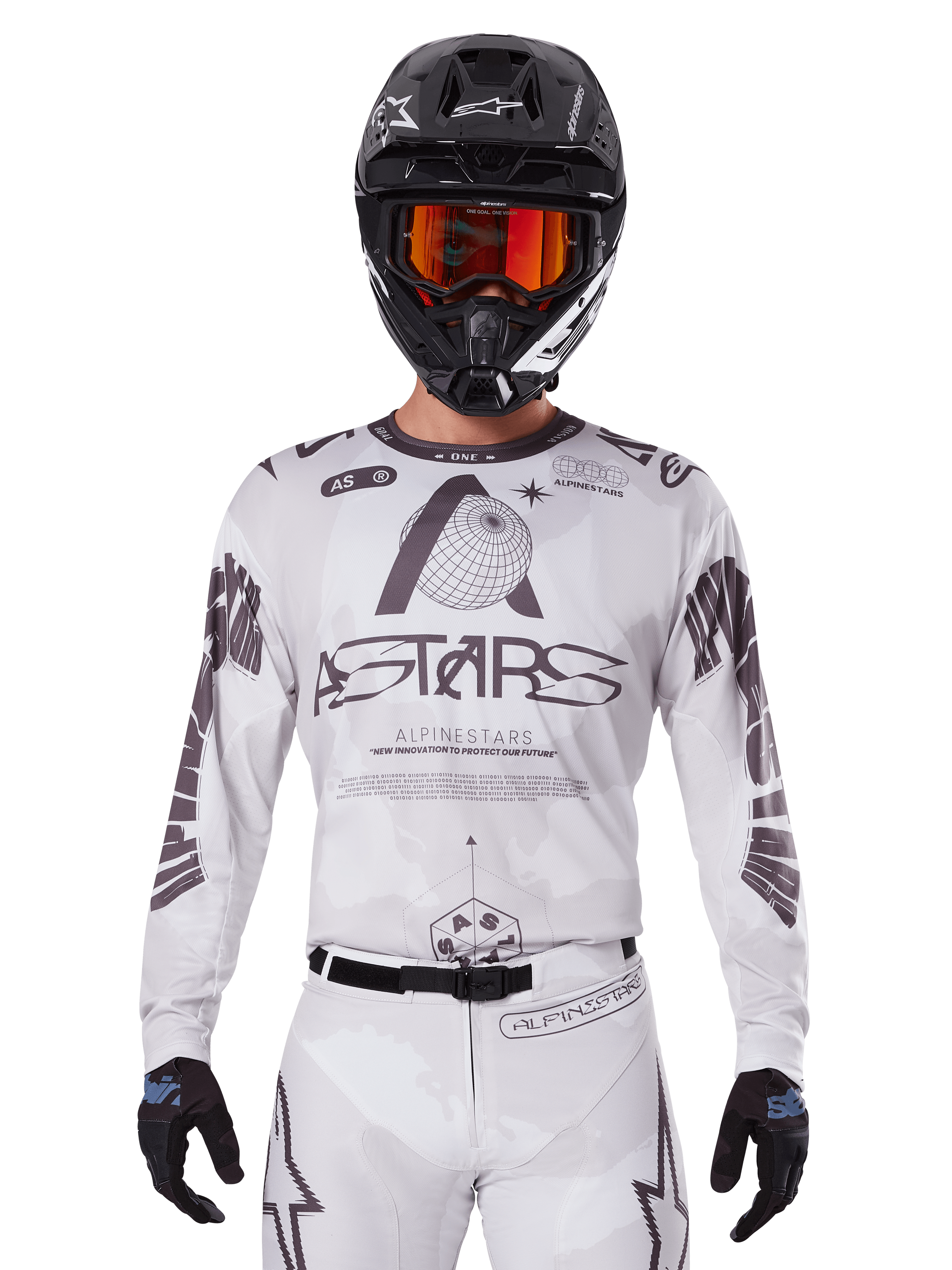 Alpinestars 2025 Racer Hollow Jersey, Motocross-Trikot, Weiß und Schwarz, getragen mit passender weißer MX-Hose und einem schwarzen Helm mit orangefarbener Brille, mit markantem Alpinestars-Branding und Globus-Grafiken, professionelle Offroad-Rennausrüstung