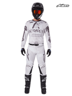 Alpinestars 2025 Racer Hollow Gear Set, men's motocross jersey and pants in light camo brown and white, front studio view on a model wearing matching helmet, gloves, and boots, lightweight performance off-road riding apparel.