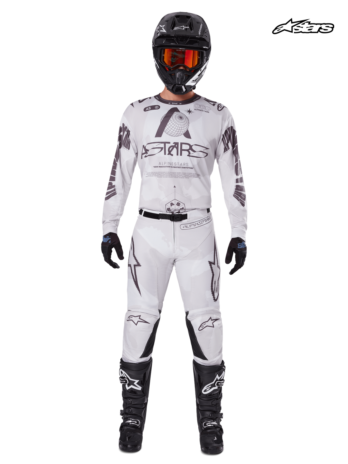 Alpinestars 2025 Racer Hollow Bekleidungsset, Motocross-Trikot und Hose für Herren in hellem Tarnbraun und Weiß, Vorderansicht im Studio an einem Model mit passendem Helm, Handschuhen und Stiefeln, leichte Offroad-Fahrbekleidung