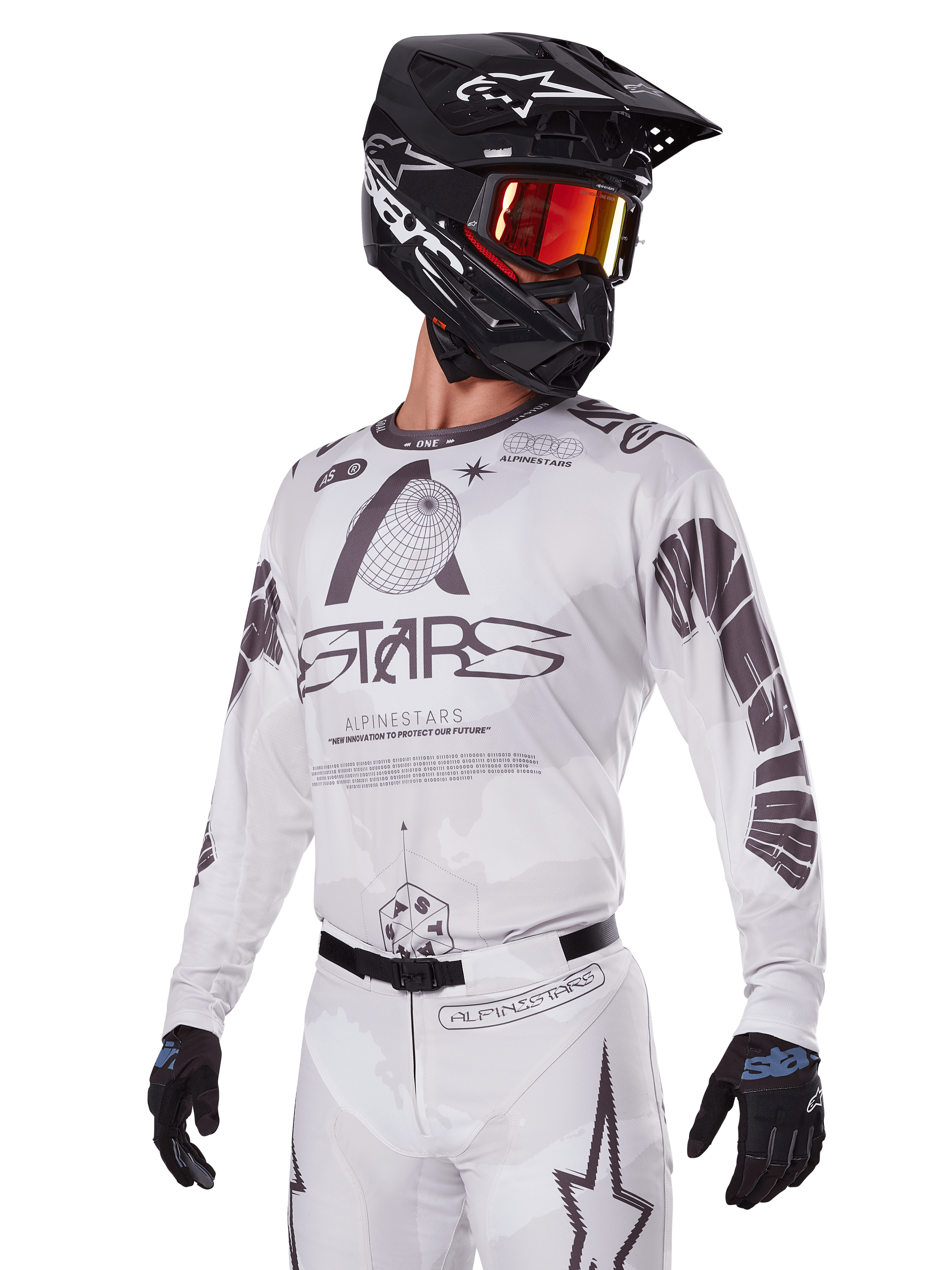Alpinestars 2025 Racer Hollow Gear Set, Motocross-Trikot und -Hose, Weiß mit schwarzen und grauen Grafiken, mit 'ASTARS'-Branding und hohlen Globus-Designs, getragen mit schwarzem Helm, rot verspiegelter Brille und schwarzen Handschuhen, konzipiert für Offroad-Performance