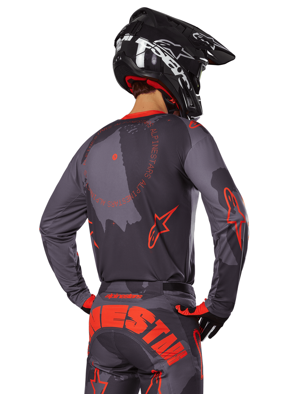 Alpinestars 2025 Racer Hollow Trikot, Rückansicht eines Motocross-Fahrers in Grau Camo und Orange Fluo Ausrüstung, mit passender Camo-Hose mit großem orangefarbenem Alpinestars-Schriftzug und einem schwarzen Helm, professionelles Offroad-Bekleidungsdesign