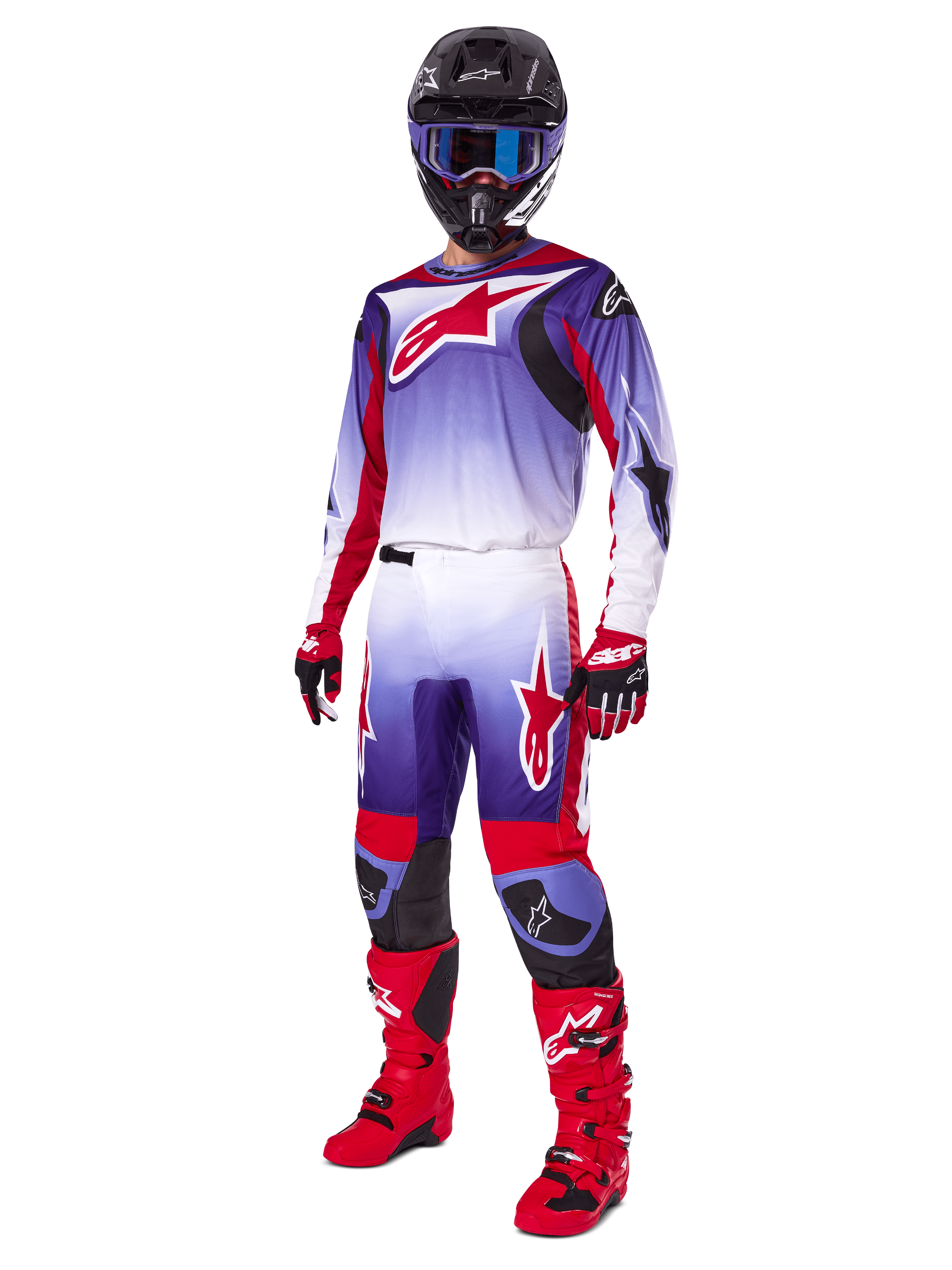 Motocross-Fahrer im Alpinestars 2025 Fluid Wurx Gear Set, lilafarbenes und leuchtend rotes Trikot mit weißen Akzenten, passende Motocross-Hose, leuchtend rote Stiefel, schwarzer Helm mit blauer Brille, rot-schwarze Handschuhe, komplette professionelle Offroad-Rennausrüstung