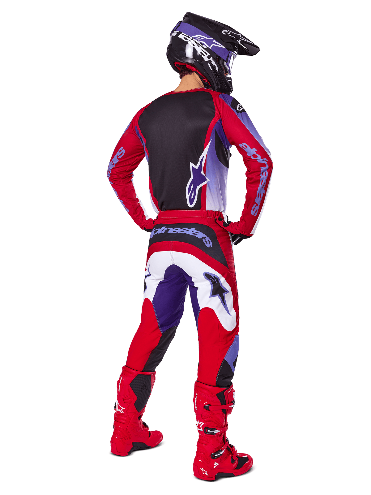 Motocross-Fahrer von hinten im Alpinestars 2025 Fluid Wurx Gear Set, lila-hellrotes Trikot mit schwarzem Rückeneinsatz, passende Motocross-Hose mit weißen und lila Akzenten, hellrote Stiefel und schwarzer Helm, professionelles Offroad-Rennoutfit