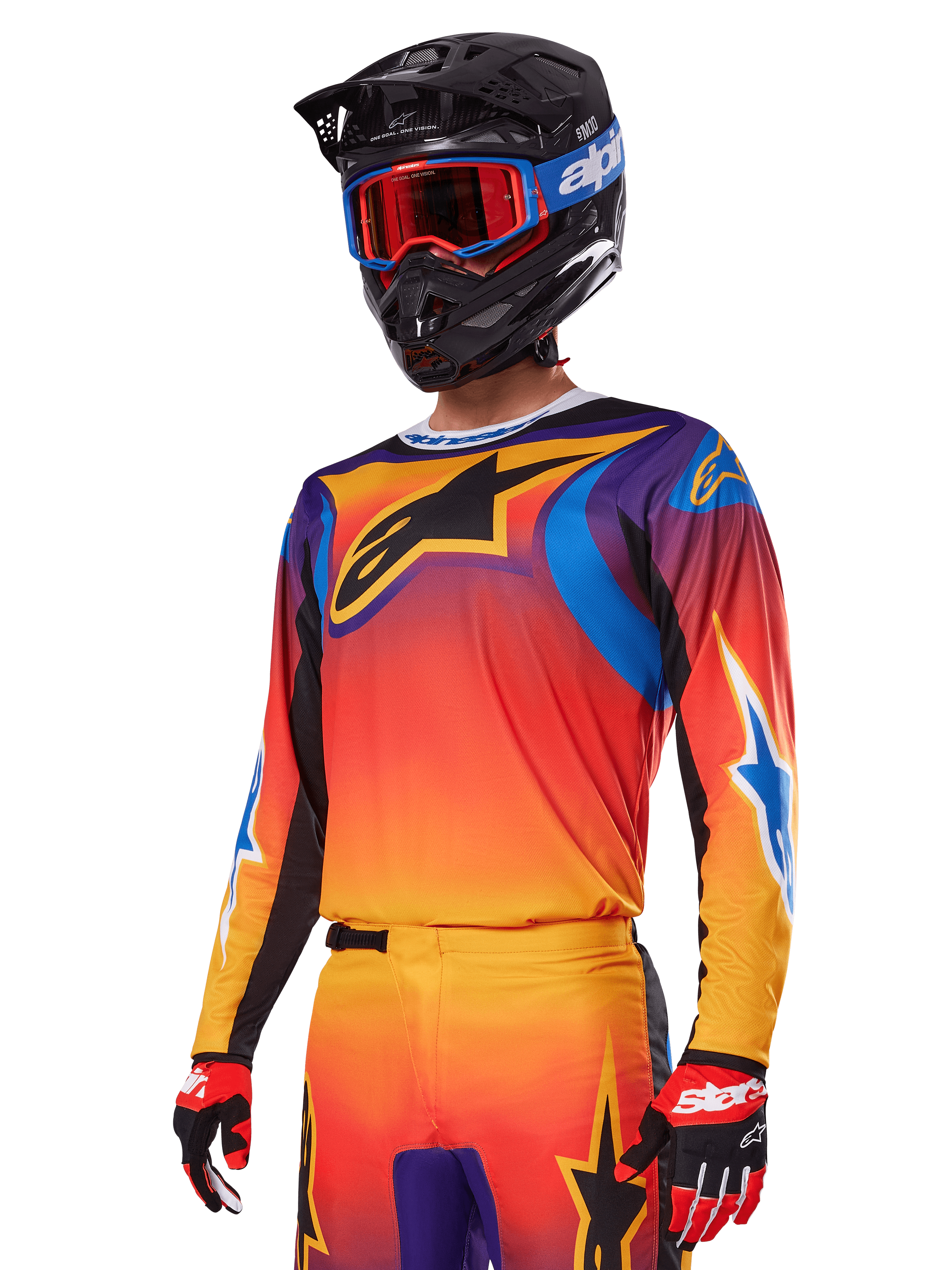Alpinestars 2025 Fluid Wurx Gear Set, Motocross-Ausrüstungsset, Farbverlauf in Orange, Lila und Blau, mit großem schwarzem A-Stars Logo, getragen mit schwarzem Helm und blauer Brille, koordiniertes Outfit für professionellen Offroad-Rennsport