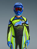 Motocross-Fahrer im Alpinestars 2026 Techstar Nomur Trikot in Dark Navy und Yellow Fluo mit blauen Akzenten, großes blaues Logo auf der Brust, passender blauer Helm und Goggles, abgestimmte Rennausrüstung für Offroad-Wettkämpfe