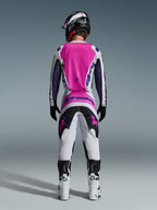 Alpinestars 2026 Fluid Grid Jersey and matching pants, Motocross Gear Set, Pink White and Purple, rear view showing ergonomic athletic fit, worn with a black helmet and white boots, designed for off-road performance.